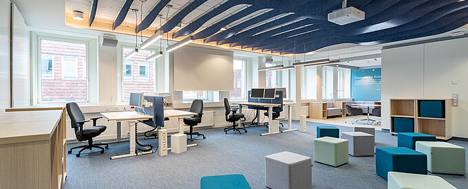Coworking Space mit Tischen und Hockern