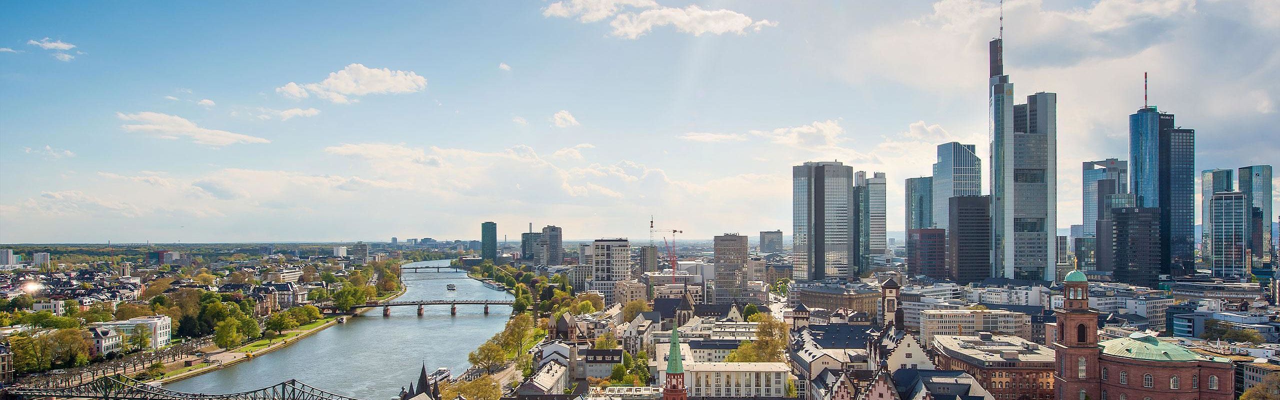 Panoramablick auf die Frankfurter Skyline mit Hochhäusern entlang des Mains bei Tageslicht.