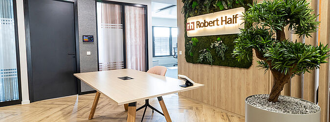 Reception area Robert Half with table and moss picture with logo Plant on the right in the picture Acoustic boxes on the left in the picture