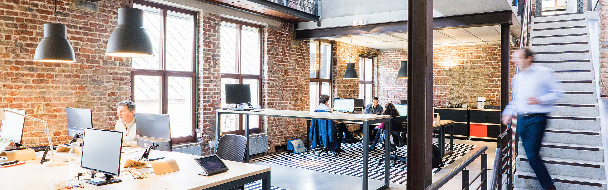 Openspace Büro im industrial Stil und Backsteinwand