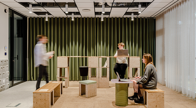 Flexibel zonierter Arbeitsbereich mit textilen Raumteilern – moderne Arbeitswelt für konzentriertes und gemeinsames Arbeiten.