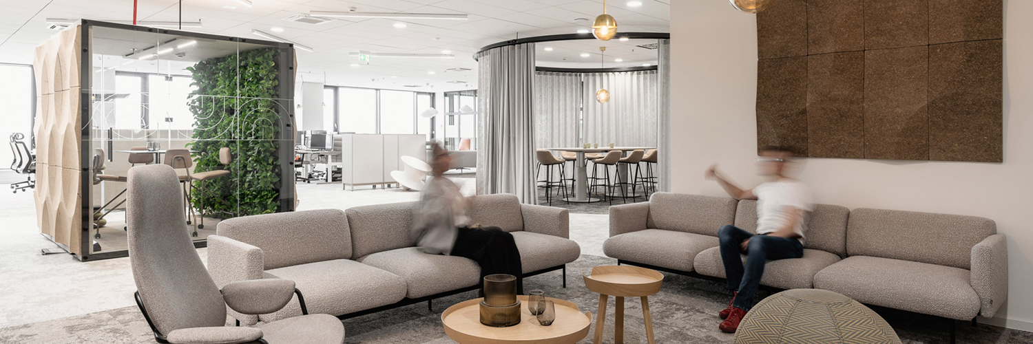 Modern workplace environment with flexible areas for communication, focused work and informal meetings. Greenery, acoustic solutions and a variety of space types support a versatile, user-centred office design.
