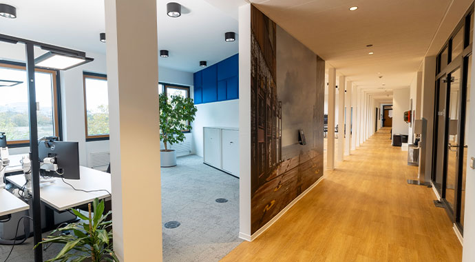 Büroausbau Hapag Lloyd: Nachher Bild von einem Flur im Büro mit Fototapete und Schreibtisch mit Bildschirm