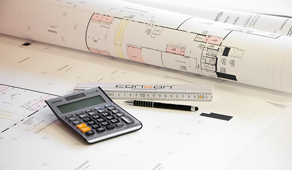 Büroausbau: Kostenschätzung und Terminplanung Schreibtisch mit Bauplänen