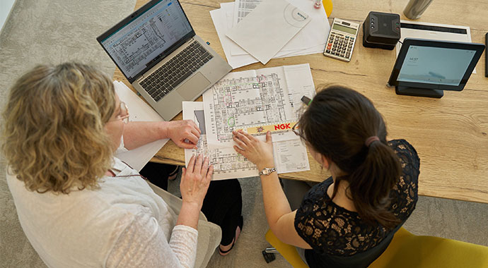 Zwei Personen schauen sich eine Grundrissplanung an