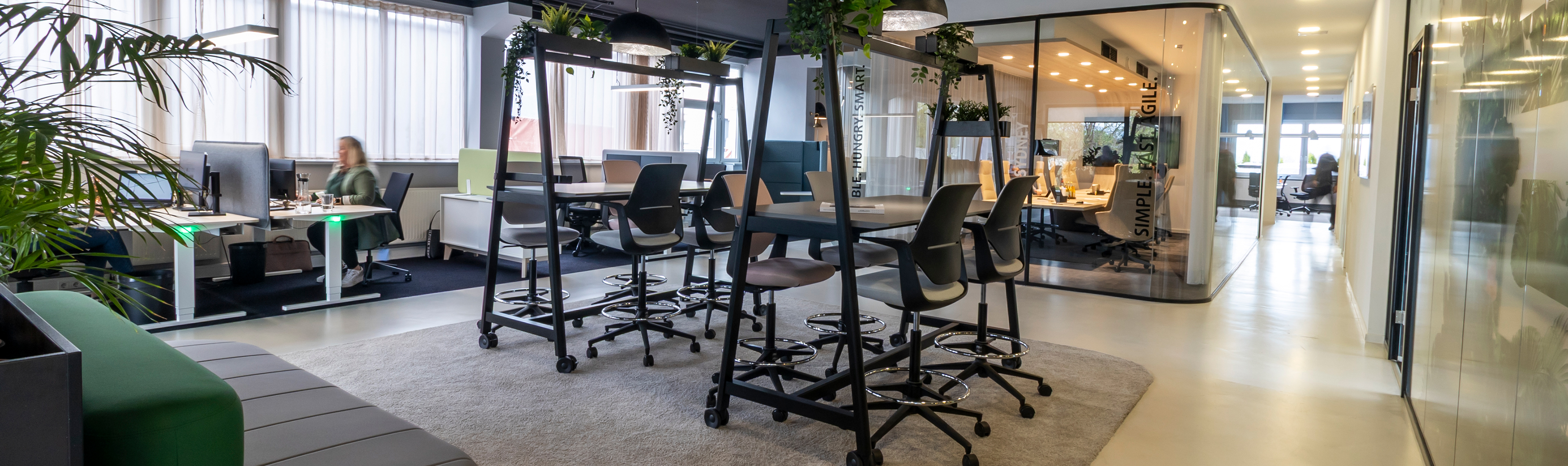 Ein modernes Büro mit Stehtischen und klassischen Schreibtischarbeitsplätzen