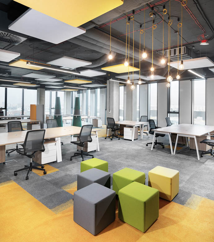 Modernes offenes Büro mit gelbem Teppich und Sitzhockern