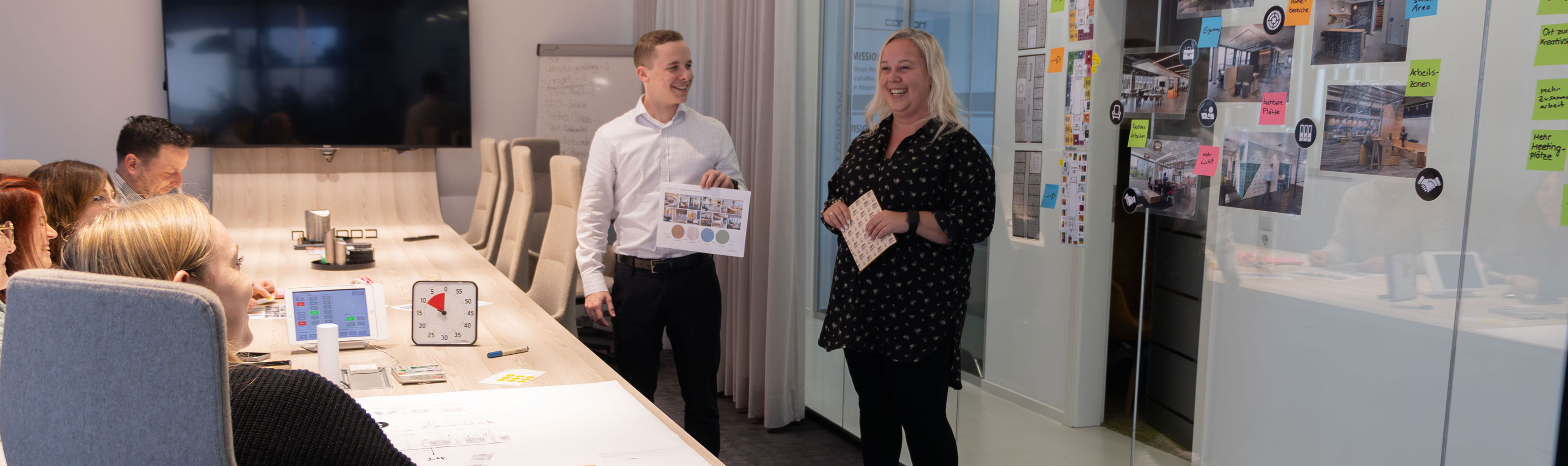 Zwei lachende Personen halten einen Impulsvortrag