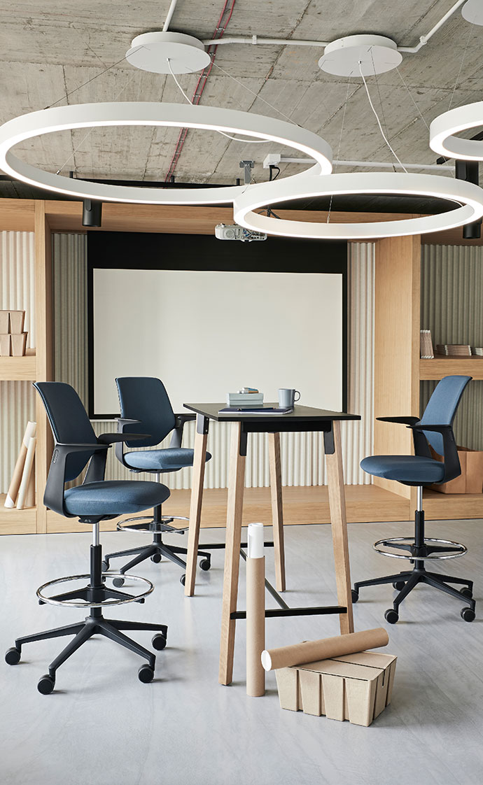 Modernes Büro mit Hochtisch und drei Stühlen und abstrakter Leuchte