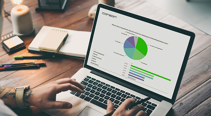 Hands working on a laptop displaying a colourful pie chart