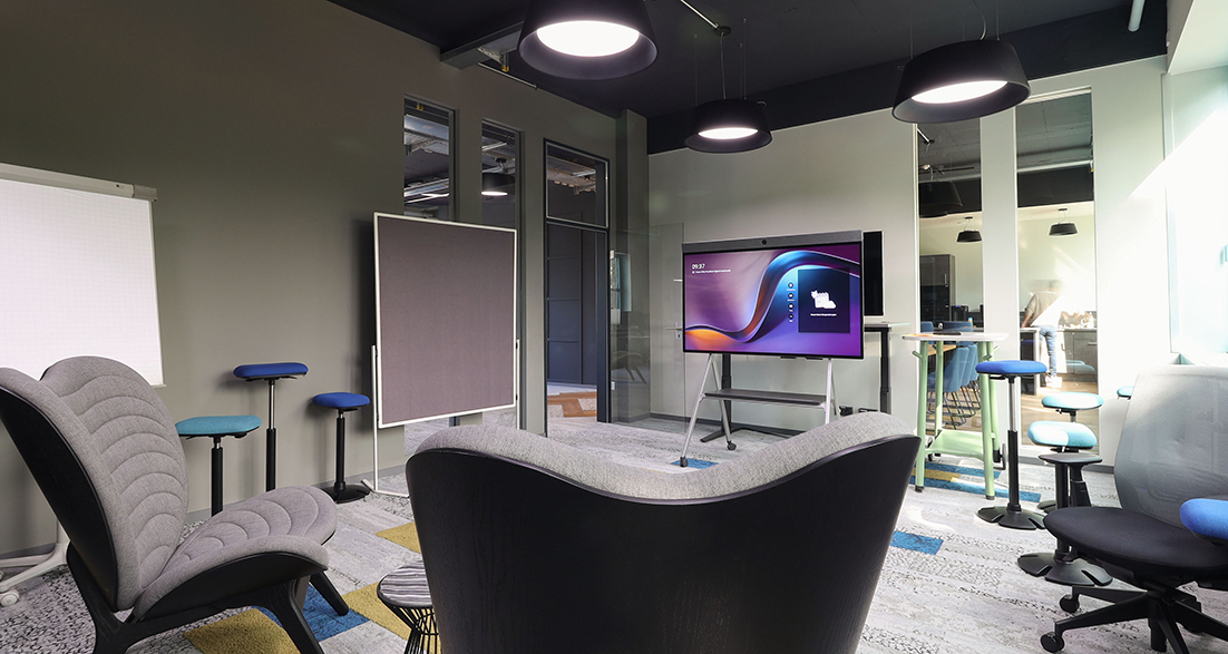 Kreativraum mit Wandbildschirm und verschiedenen Sitzmöglichkeiten