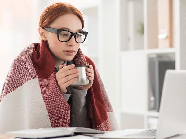 Frau im Büro friert Raumklima im Büro