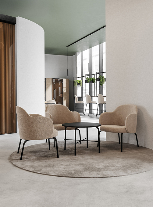 Modern lounge and waiting area with armchairs and round table in a sustainably designed office building