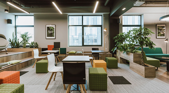 Open office space with flexible seating areas, plants and collaborative work zones