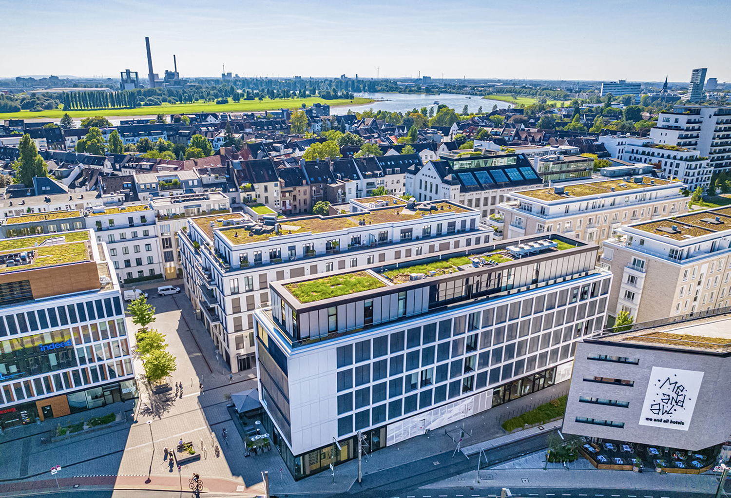 Aerial view of modern office buildings with green roofs representing sustainable ESG real estate
