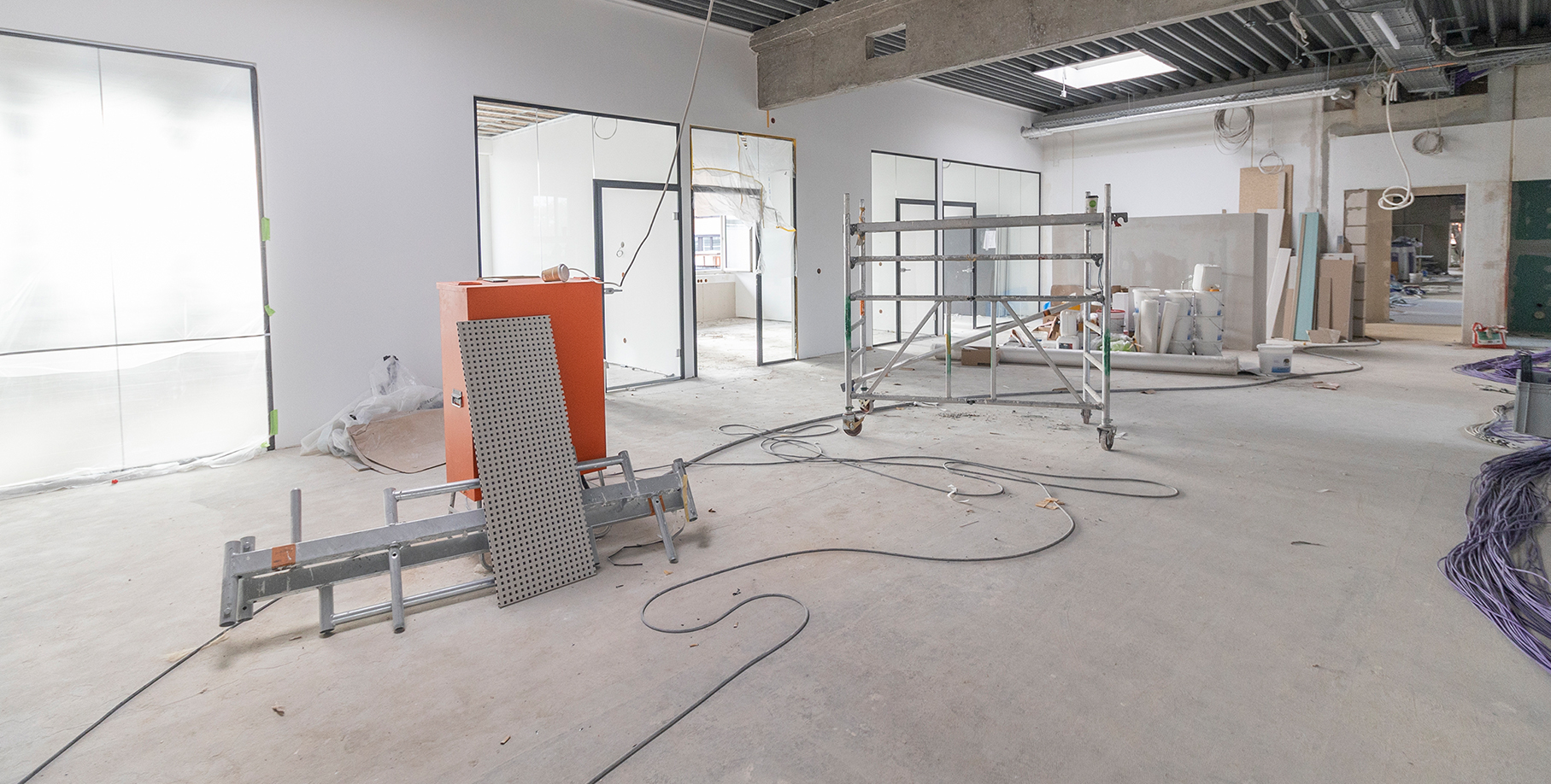 Baustelle mit verkleideten Glaswänden und Werkzeug