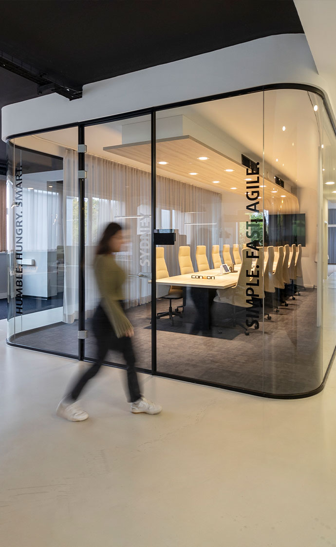 New Work Bürokonzepte - Wir beraten Sie gern! Frau läuft vor großem Konferenzraum mit Glaswänden