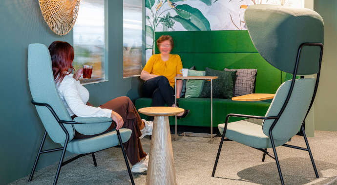 coneon: Ergonomie & Wohlbefinden im Büro Zwei Personen sitzen in modernem Loungebereich