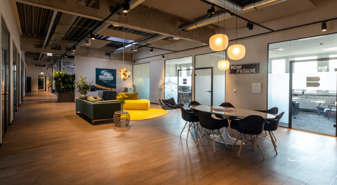 Großer Loungebereich mit Glaswänden und gelben Akzenten