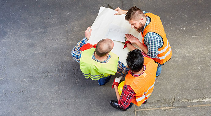 Innenausbau Bauarbeiter bei Bauplan Besprechung