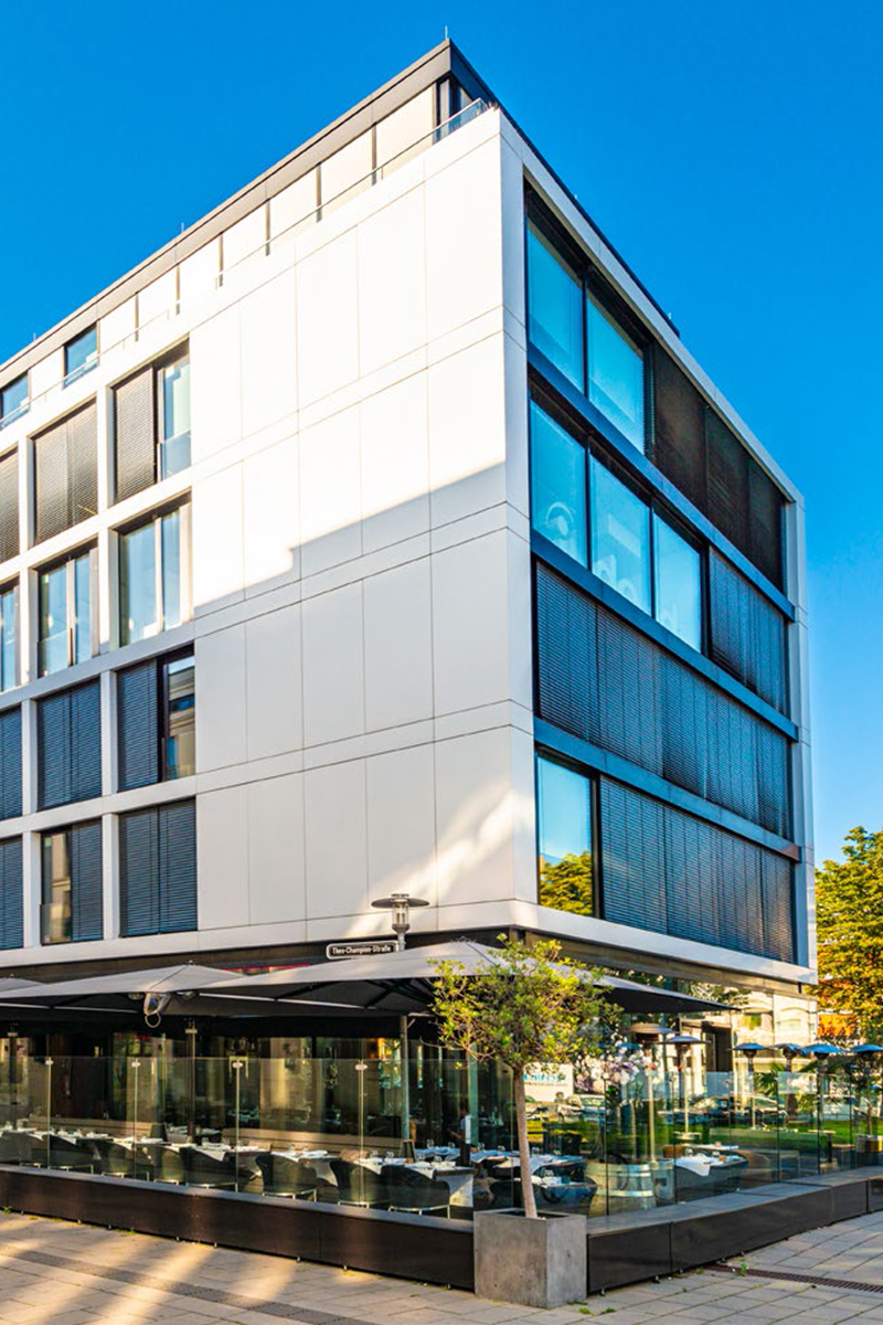 Modernes Bürogebäude mit Gasfronten und Terassenbereich vor dem Komplex