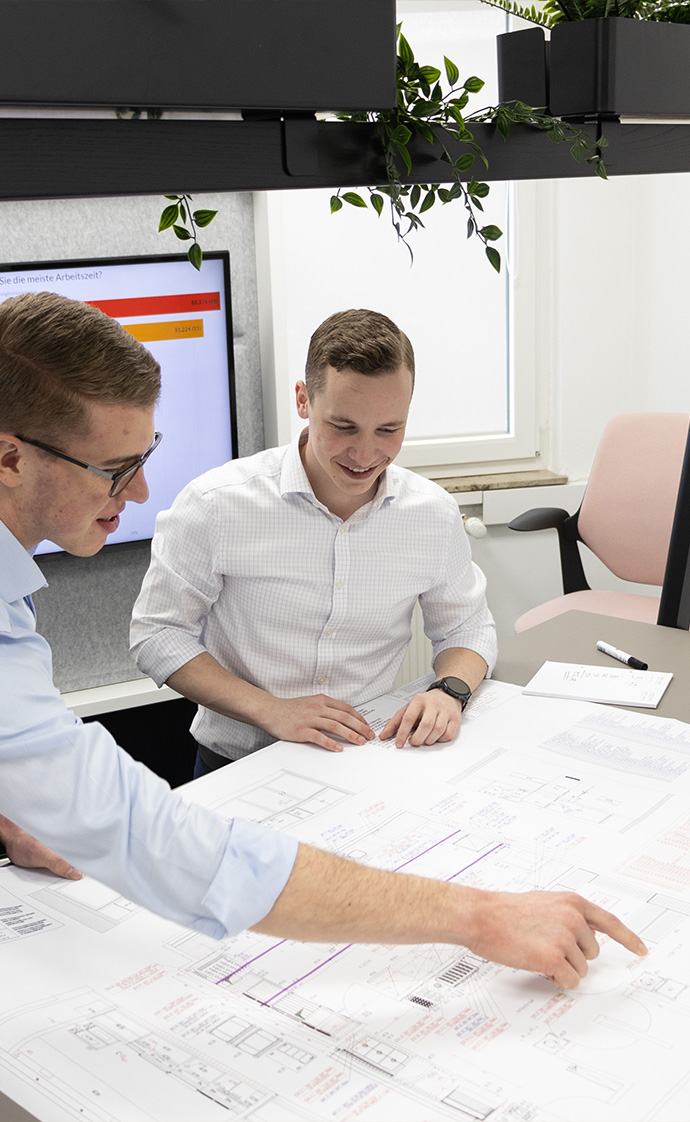 Bürokonzepte von coneon - jetzt anfragen! Zwei Kollegen arbeiten gemeinsam an einem Raumplan