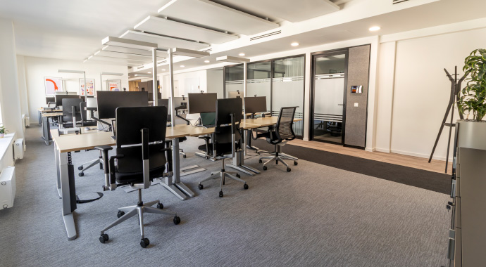 Offene Arbeitsfläche mit Schreibtischen und Fokusräumen