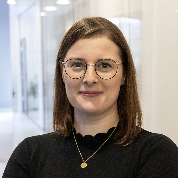 Eine lächelnde Frau mit schwarzem Oberteil und Kette