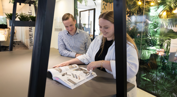 Büroeinrichtung mit coneon - besuchen Sie uns! Glückliche Mitarbeitende im Gespräch