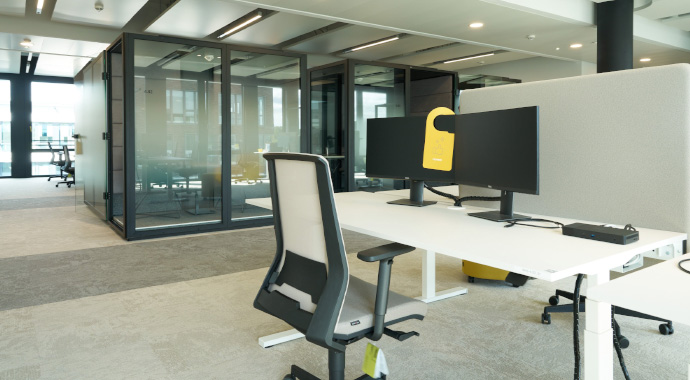 Offener Arbeitsplatz mit Akustikboxen im Hintergrund